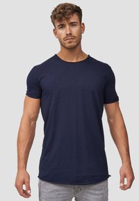 Camisa de manga corta azul marino con cuello redondo, hecha de tejido suave, con un corte recto y una textura sutil.