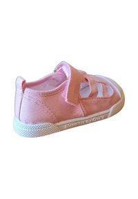 Zapato de tela rosa con aberturas en los laterales, correa de velcro y suela de goma blanca texturizada. Presenta un logo en un lado y material suave.