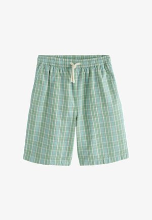 Grüne und blaue kariert elastische Taillenshorts mit weißer Kordel, die zu einer Schleife gebunden ist, vor weißem Hintergrund.