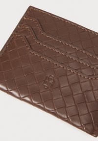 Portafoglio in pelle marrone con texture intrecciata, dotato di più scomparti per carte e dettaglio del logo in rilievo. Linee pulite e finitura raffinata.