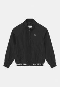 Černá bomber bunda se zipem, žebrovanými manžetami a lemem, tónovým logem na hrudi a kontrastním bílým názvem značky na pase.