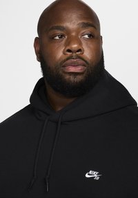 Μαύρο φούτερ με κουκούλα και κορδόνια, με λευκό λογότυπο Nike SB στο στήθος. Υφή από απαλό ύφασμα, σχεδίαση με άνετη εφαρμογή.