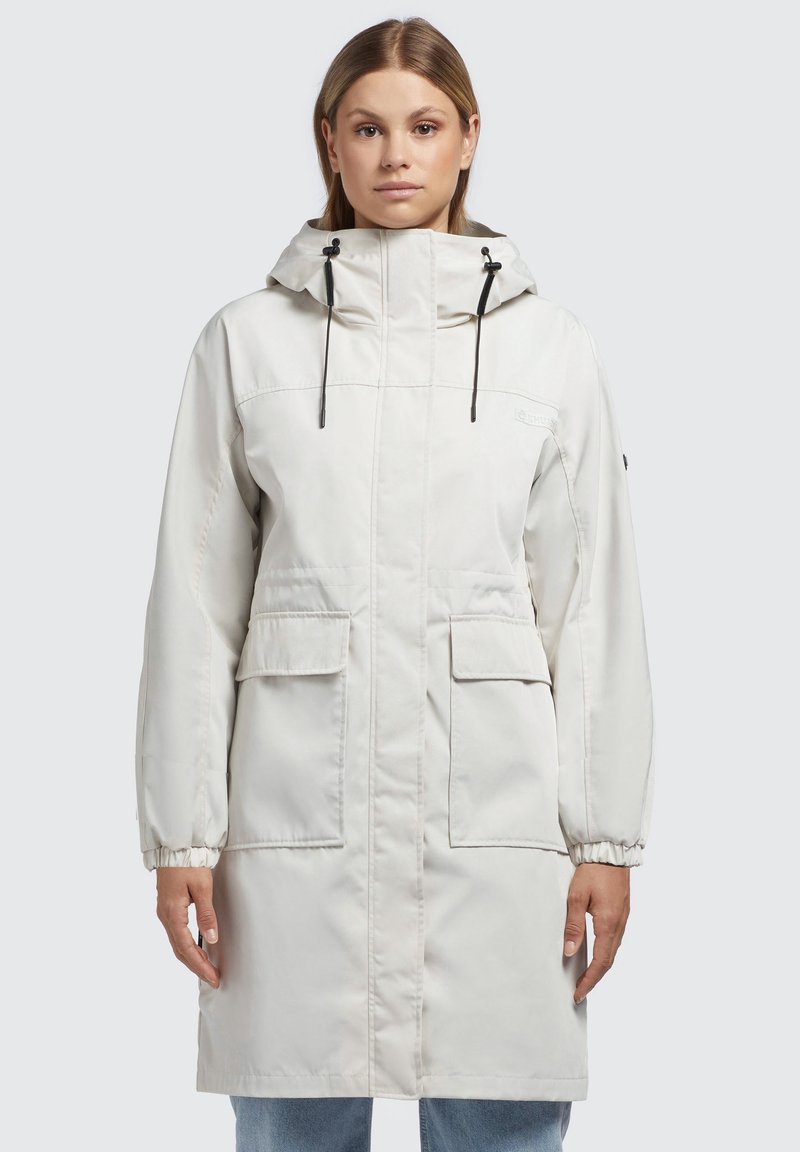 Parka leggera di colore crema con cappuccio, polsi elasticizzati, due tasche frontali e dettagli con cordino. Tessuto liscio, design lungo fino al ginocchio.