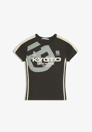 Tricou sport de culoare gri închis, cu mâneci scurte, dungi bej și text mare „KYOTO STAY MOVING ATHLETICS” și logo-uri pe partea din față.