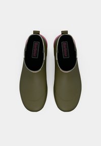 Πράσινα λαστιχένια μπότες αστραγάλου με λείο φινίρισμα, ροζ σημεία στη φτέρνα και μαύρο εσωτερικό με το όνομα της μάρκας «Barbour».