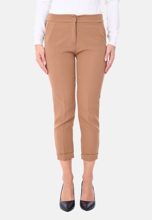 Pantaloni marroni aderenti con orlo arrotolato, dotati di chiusura frontale con bottone, realizzati in tessuto liscio e elastico. Indossati con tacchi alti neri.