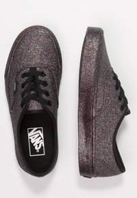 Svarta kanvasskor täckta med flerfärgad glitter, med svarta snören, rund tå och platt sula. Logotyp synlig inuti.