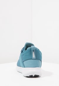 Tyrkysová sportovní bota s síťovaným svrškem, polstrovaným límcem a bílou mezipodešví. Obsahuje zadní poutko a reflexní akcenty.