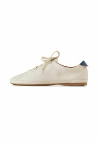 Zapatilla de cuero blanca con una textura suave, puntera redondeada, suela plana y un acento azul en el talón. Cuenta con un diseño de cordones sencillo.