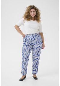 White knit top with short sleeves paired with high-waisted, loose-fitting pants featuring a blue palm leaf pattern on a white background.