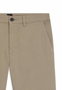 Pantaloni beige in misto cotone con frontale piatto, dotati di due tasche laterali e chiusura con un bottone. Tessuto liscio con cuciture visibili.