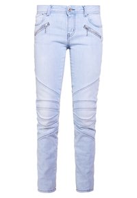 Vaqueros de mezclilla azul claro con un corte ajustado, cremalleras decorativas en los bolsillos frontales y paneles texturizados a lo largo de las piernas.