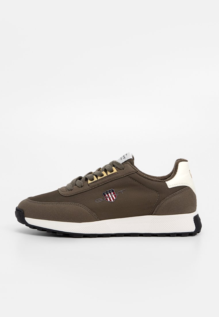 Brązowe sportowe sneakersy z tkaninowej cholewki, z logo na naszywce, kontrastowym białym piętą i czarną gumową podeszwą. Sznurówki.