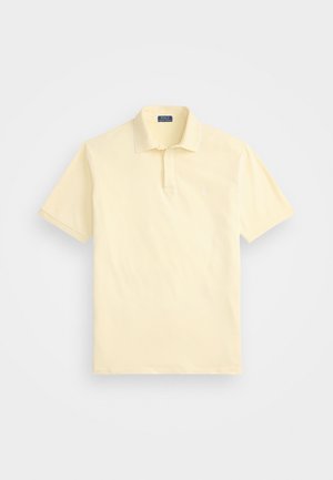 Polotröja i ljusgul, kort ärm, tillverkad av bomull, klassisk krage, diskret logotyp på bröstet, kontrasterande kragskiss.