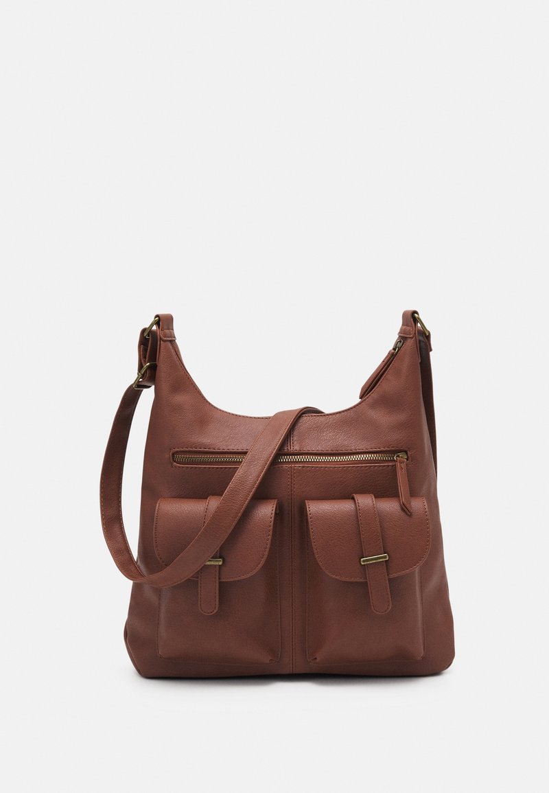 Sac à bandoulière en cuir marron avec deux poches avant, une poche zippée au-dessus, et une sangle réglable sur un fond uni.