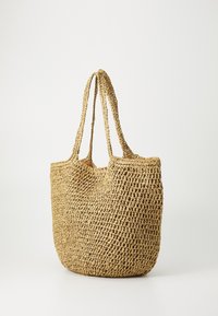 Geweven rieten draagtas met twee lange handvatten, beige kleur, rechthoekige vorm, gestructureerd oppervlak en een open bovenkant.