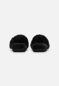 Black slippers with a soft, fluffy texture, open-toe design, and wide strap. Flat sole, lightweight, and simple silhouette.