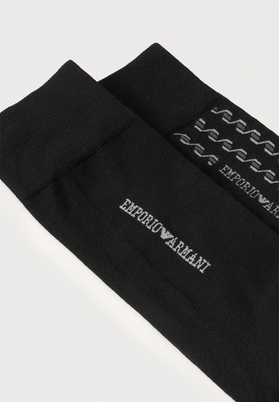 Paire de chaussettes noires Emporio Armani avec bords-côtes, l'une affichant le nom de la marque et l'autre un motif de logo répétitif en gris.