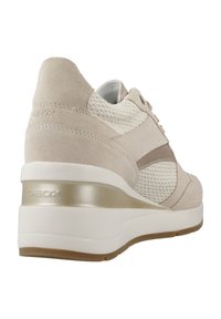 Sneaker beige e bianco con materiali in suede e rete, forma arrotondata e una spessa suola bianca con un accento metallico. Marchio Geox in evidenza.