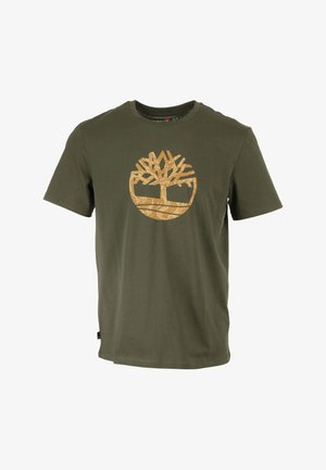 T-shirt en coton vert olive avec un grand logo d'arbre beige imprimé sur le devant. Design classique à col rond avec des manches courtes.