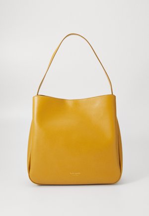 Yellow leather tote bag with a smooth texture, wide opening, and a single shoulder strap. Features subtle branding at the bottom.