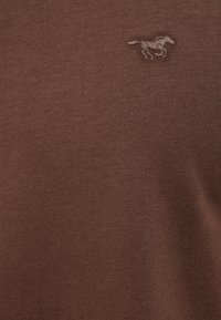 Braunes Baumwollhemd mit einer strukturierten Oberfläche, auf der Brust mit einem kleinen, gestickten Pferdelogo in einem etwas helleren Farbton.