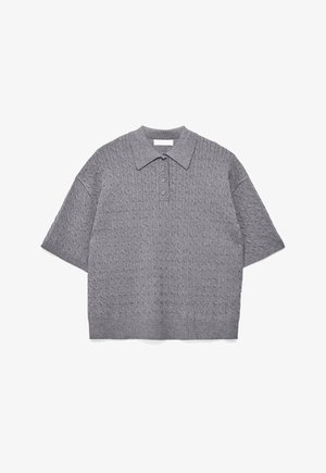 Grå strikket polo med korte ærmer og kabelmønster, tre knapper samt ribkant ved kant og krave, lagt fladt på hvid baggrund.