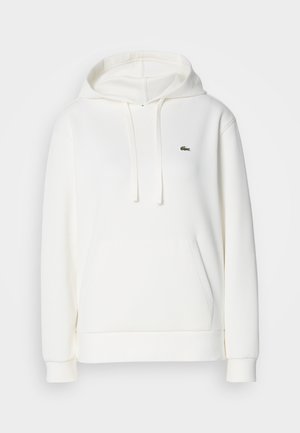 Weißer Kapuzenpullover aus weichem Stoff. Verfügt über eine Fronttasche und ein kleines grünes Logo auf der Brust gestickt.