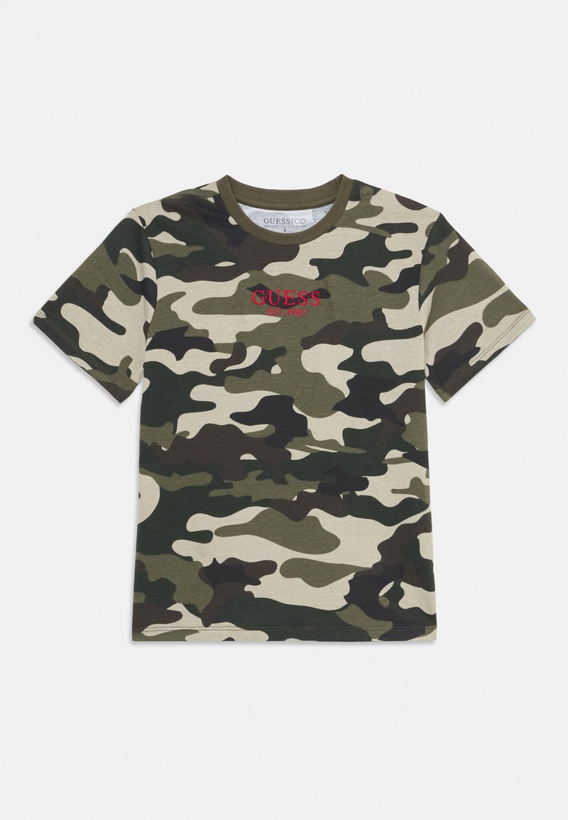 T-shirt en coton à motif camouflage présentant des verts et des bruns, col rond, manches courtes, avec le logo rouge "GUESS" au centre.