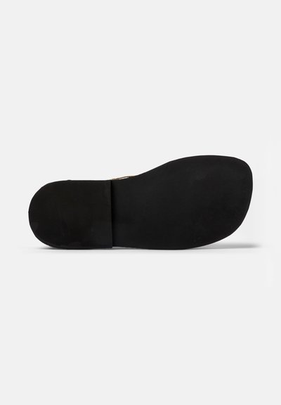 Sole in gomma nera con superficie liscia e forma arrotondata. Presenta una leggera curva nella zona delle dita e un tacco piatto. Design minimalista.