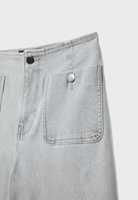 Sive jeans hlače z visokim pasom, dvema sprednjima žepoma in srebrnimi gumbki na pasu ter žepih.