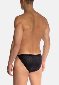 Czarne slipy kąpielowe z geometrycznym wzorem, teksturowaną tkaniną i gładkim pasem na talii, zaprojektowane dla dopasowanego kroju.