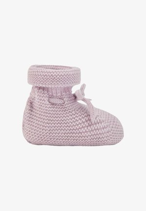 Chausson de bébé tricoté rose doux avec un revers roulé et un nœud attaché sur le côté, isolé sur fond blanc.