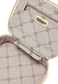 Brun kosmetikapung med lynlås og et indre prydet med et gentaget logo mønster i grå. Indeholder en lille lynlåslomme til organiseringsformål.