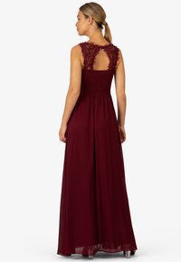 Bordeaux maxi-jurk met een geschouderde lijfje en bloemenkantdetails op de schouders, met een keyhole rug en een vloeiende rok.