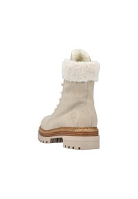 Bottine en suède beige avec un col en fausse fourrure, un design à lacets et une semelle en caoutchouc texturée avec des détails superposés.