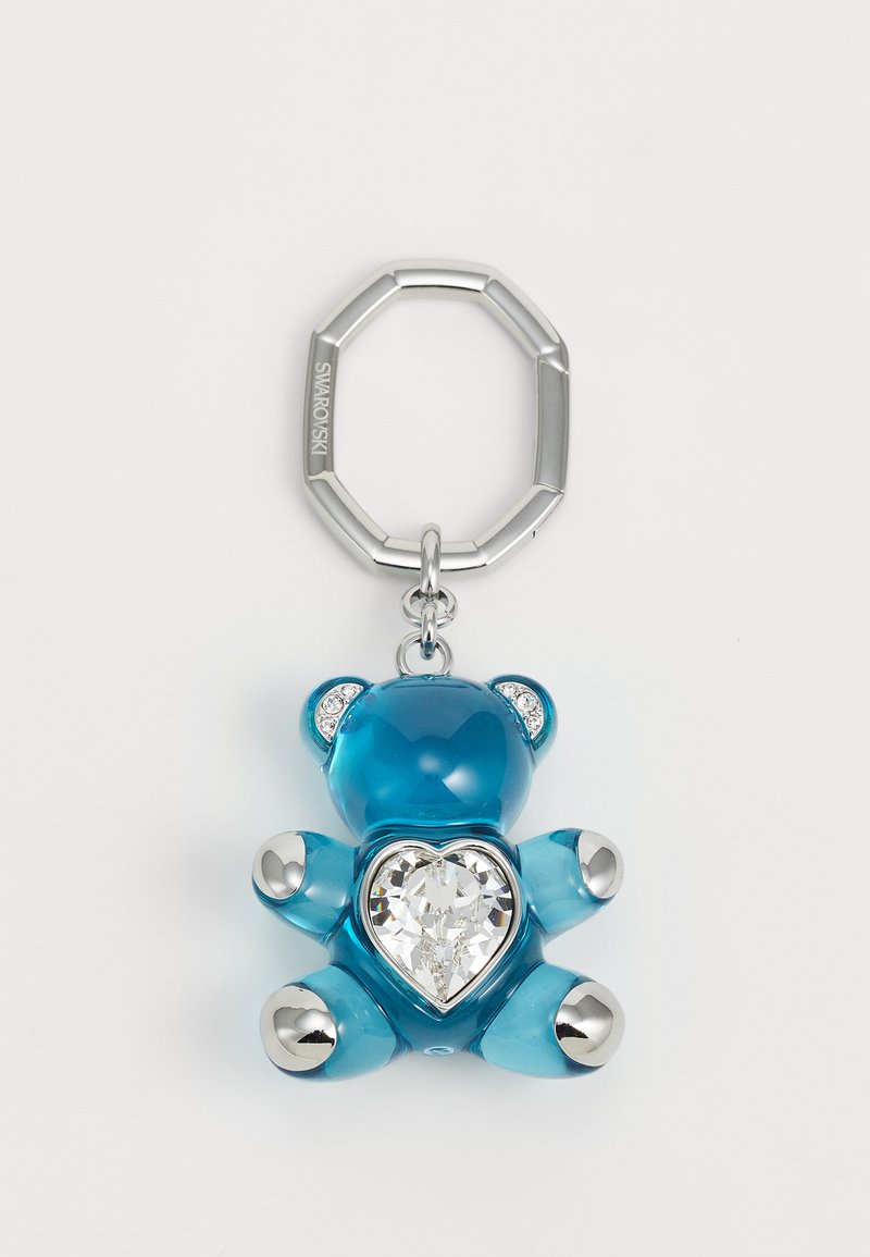 A blue bear keychain, made of transparent material, featuring a heart-shaped crystal and silver accents on feet and ears.