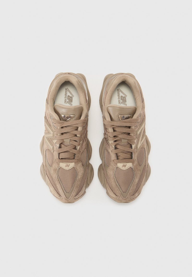 Beżowe sneakersy sportowe z teksturowanej zamszowej i siatkowej cholewki, okrągłym noskiem oraz grubą gumową podeszwą. Posiadają centralny system sznurowania i akcenty z logo.