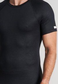 Black short-sleeve fitted T-shirt made from a smooth fabric, featuring a rounded neckline and a small white accent on the sleeve.