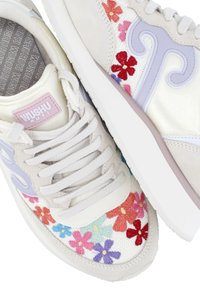 Sneakers bianchi con ricami floreali in rosso, rosa, blu e viola. Presentano un'etichetta di marca rosa e accenti curvi di un leggero viola.