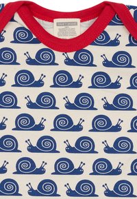 Tessuto in cotone biologico con un motivo ripetuto di chiocciole blu navy su uno sfondo crema, con un collo a costine rosso.