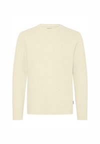Jasna kremowa koszula z długim rękawem i okrągłym dekoltem, o fakturowanej tkaninie i małym logo na piersi. Prosty design bez wzorów czy akcentów.