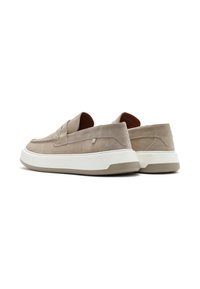 Beige suede slip-on shoes with a white midsole and tan outsole, featuring stitched accents and a smooth texture.