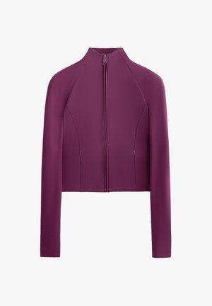 Priliehavá, skrátená bunda v tmavofialovej farbe, vyrobená z hladkej látky. Má vysoký golier, dlhé rukávy a predný zips so dvoma bočnými vreckami.