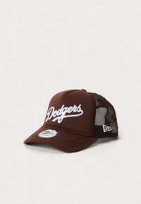 Culoare maro cu capac de baseball Dodgers, cu logo brodat alb, panouri din plasă la spate și curea ajustabilă, pe un fundal deschis.
