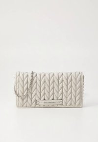 White quilted handbag with a chain strap, featuring a distinct woven pattern and silver hardware plaque displaying the brand name.