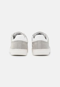 Gray suede sneakers with white accents, low-top design, flat rubber sole, padded collar, and logo detail on the heel.