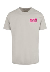 Lys grå bomulds T-shirt med korte ærmer og rund hals. Frontprintet i fed pink tekst står der "MEIN ❤️ SCHLÄGT SCHLAGER."