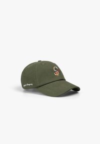 Gorra de béisbol verde oliva con una letra "S" floral bordada en el frente y texto blanco "Scotch & Soda" en el lado.