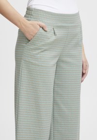 Lichtblauwe en tan geruite broeken met een brede pijpdesign, voorzien van een comfortabele tailleband en zijzakken. Glad stoffen textuur.